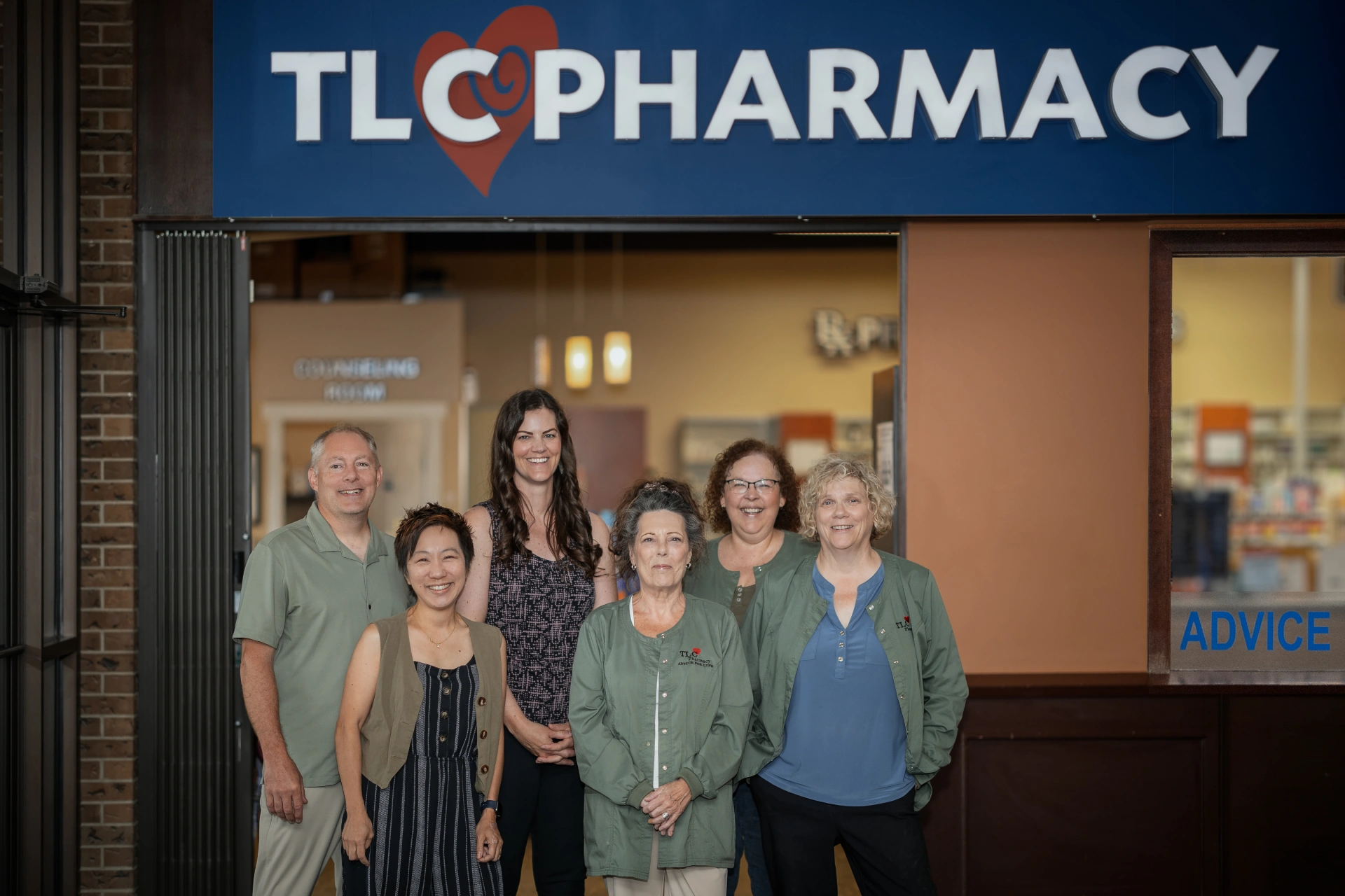TLC Pharmacy staff team standing together in front of the store